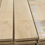 Width of edged hornbeam boards, 52 mm, stacked in a warehouse close-up.