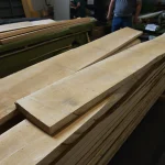 Stack of first-grade edged maple boards in a woodworking warehouse.