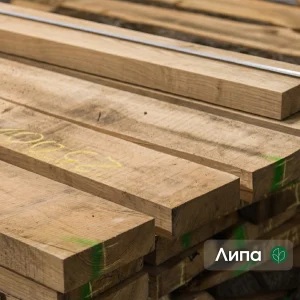 A close-up of stacked first-grade edged linden boards showing wood texture.