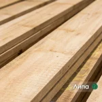 Close-up of stacked extra grade edged linden boards showing the smooth wood texture.