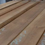 Perspective view along the surface of stacked first-grade edged spruce boards.