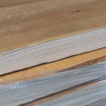 Detailed view of the edge and annual growth rings of a spruce lumber board.