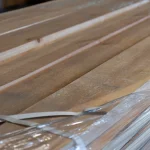 Packaged stack of edged spruce boards wrapped in protective stretch film.