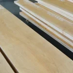 Stack of edged alder boards with handwritten dimensions in a warehouse.