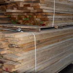 Side view of stacked edged ash boards showing the clean parallel cuts and natural wood color.
