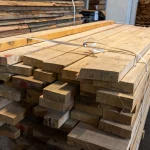 Detailed view of the ends of first-grade edged ash boards stacked and secured with plastic straps.