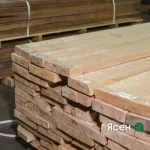 A neat stack of extra grade edged ash boards with marked dimensions in a warehouse.