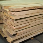 Side view of stacked ash boards highlighting their straight edges and natural color.