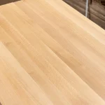Diagonal view of the finely sanded surface of a solid-lamella beech panel.