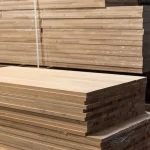Large stack of finished solid beech edge-glued panels stored in a woodworking workshop.