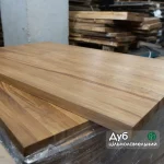 Solid oak furniture panel with a watermark highlighting the premium solid-lamella structure.
