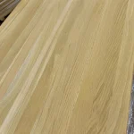 Detailed view of the smooth surface of a solid-lamella oak panel showing long continuous wood strips.