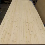 Full-length view of a 3x1.22 m solid-lamella pine furniture panel on a workbench.