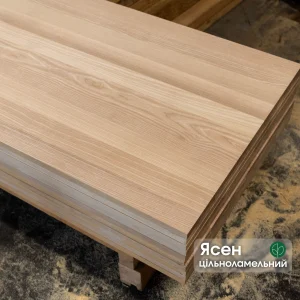 Stack of solid-lamella ash edge-glued panels showing the smooth surface and natural wood grain.