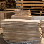 Front view of a neatly stacked pile of ash edge-glued boards on a pallet.