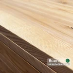 Close-up of the edge and smooth surface of a solid-lamella ash furniture panel.