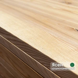 Close-up of the edge and smooth surface of a solid-lamella ash furniture panel.