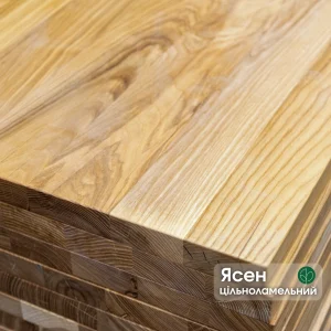 Close-up of stacked solid-lamella ash edge-glued panels showing the end grain and natural wood texture.
