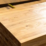 Smooth surface of a rustic ash edge-glued panel highlighting natural knots and rich grain character.