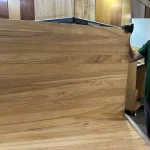 Solid ash edge-glued panel held vertically, showcasing the natural rustic wood pattern.