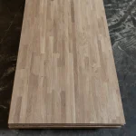 Full top view of a stack of finger-jointed oak furniture boards.