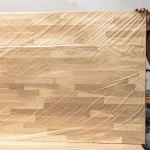 Finger-jointed oak panel wrapped in protective plastic film.