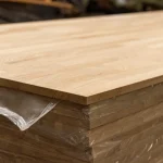 Close-up of the 20 mm edge of a finger-jointed oak panel on a stack.