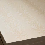 Wavy grain pattern of white ash veneer on the blockboard surface close-up.