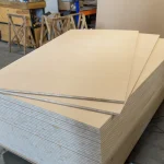 High-angle view of a neat stack of 13 mm HDF-faced blockboards in a workshop.