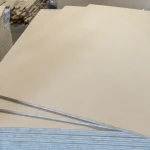 Stacked sheets of HDF-faced blockboard in a warehouse, showing the uniform surface and clean edges.