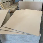 HDF-faced blockboard sheets stacked in a woodworking warehouse environment.