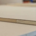 Extreme close-up of the 18 mm blockboard edge showing HDF layers and wood core joint.