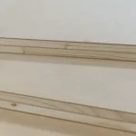 Detailed view of the multi-layer structure of HDF-faced blockboards stacked on top of each other.