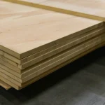 Side view of stacked ceiba veneered blockboards showing the solid wood core structure.