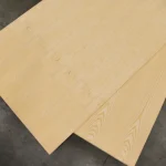 Two sheets of white ash veneered blockboard laid out on a concrete floor.