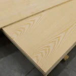 Corner view of white ash veneered blockboard sheets showing the edge and surface grain.