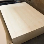 Stack of white ash veneered blockboards stored in a woodworking warehouse.