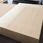 Perspective view of a stack of light-colored white ash veneered boards.