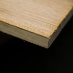 Close-up of the corner of a 14mm oak veneered blockboard sheet, showing the clean cut and veneer layer.