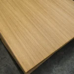 Close-up texture of natural oak veneer on a blockboard panel.