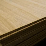 Stack of oak veneered blockboards in a warehouse, showing the flat surface and thickness of the sheets.