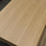 Diagonal view of the smooth surface of an oak veneered blockboard sheet.