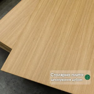 Close-up of stacked oak veneered blockboard panels showing the smooth natural wood grain texture.