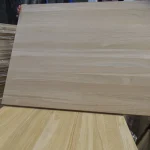 A person holding a solid-lamella oak furniture panel to showcase its flat surface.