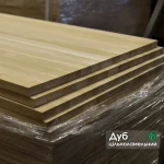 Stack of oak furniture panels with text overlay indicating solid lamella oak.