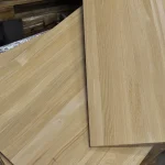 Detailed view of the edge and surface of overlapping solid oak furniture boards.