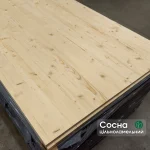 Top view of a solid-lameled pine furniture board in a stack, showcasing the natural wood grain.