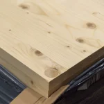 Close-up of the corner and edge of a 27mm thick solid-lameled pine furniture board.