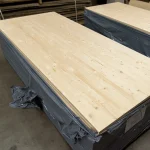 High-angle view of a stack of solid-lameled pine boards, highlighting their length and quality.