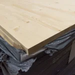 Close-up of the clean cut edge of a 27mm solid-lameled pine board on a pallet.